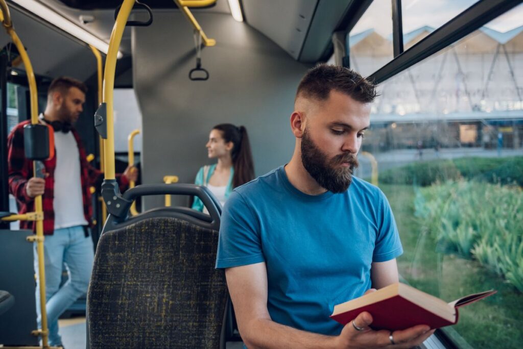 Person reading book while on public transporation