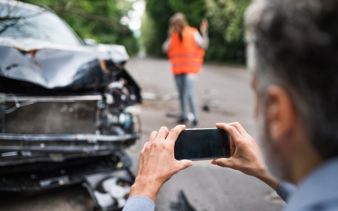 person taking photo after car accident