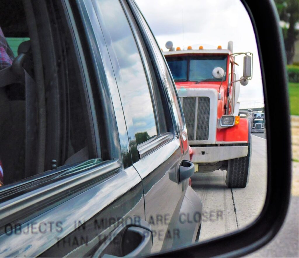 semi truck driving behind passenger car