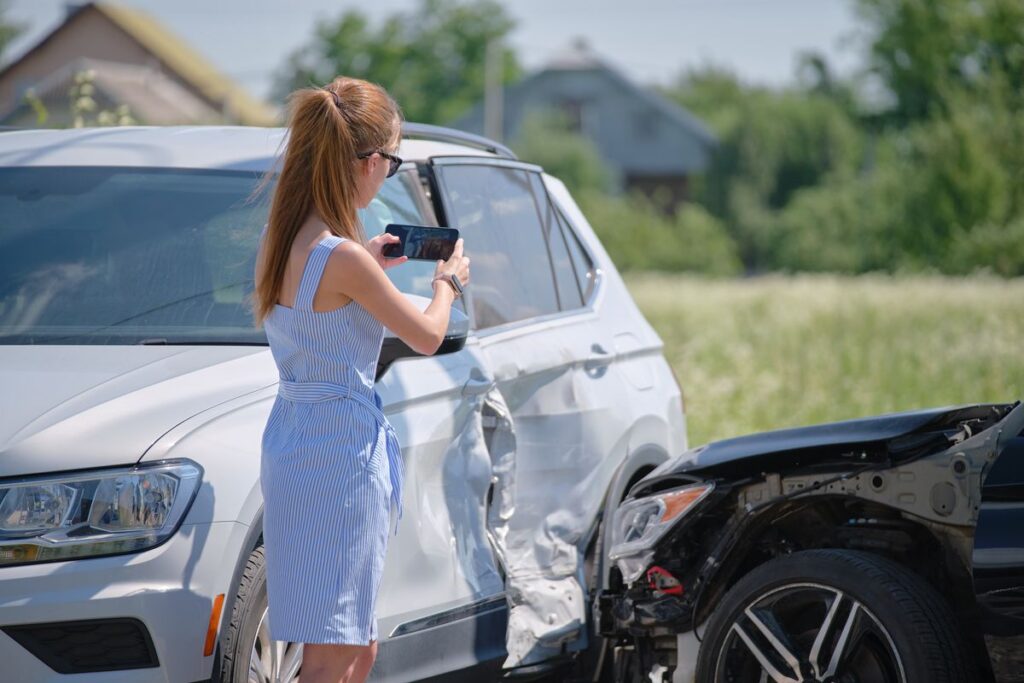 woman taking photo after car accident
