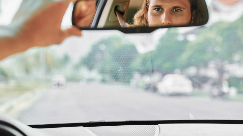 Person checking rearview mirror while driving